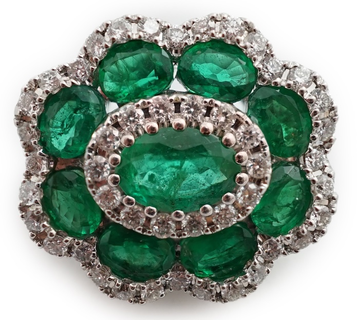 A mid to late 20th century white gold, emerald and diamond cluster set brooch